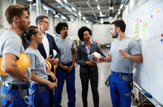 A manufacturing team whiteboarding a problem