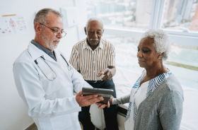 Doctor displays tablet to couple