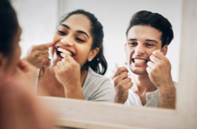 Image: Couple flossing in mirror