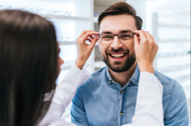 Image: Vision provider adjusting fit of glasses on smiling patient