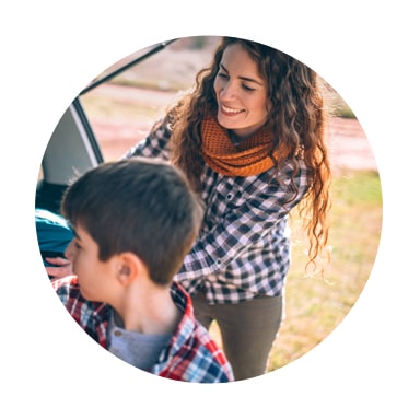 Image of a mother and son smiling while packing back of a car