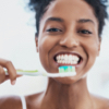 Image: Smiling woman brushing teeth