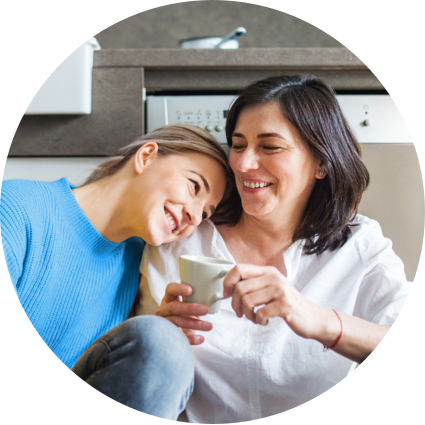 Image two smiling women sharing coffee