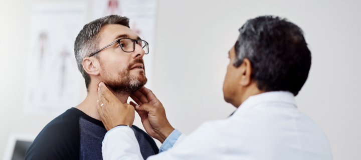 Doctor checking man's neck lymph nodes