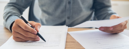 person's hands filling out paperwork
