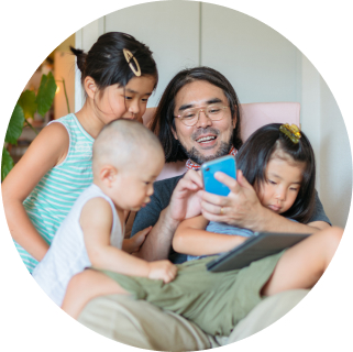 Image of family smiling and looking at cell phone screen