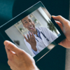 Doctor having a video office visit with a patient on a tablet device