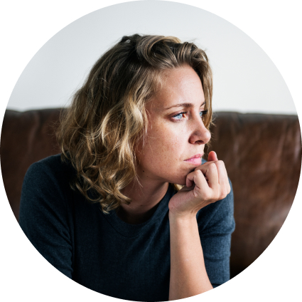 Woman sitting on a couch with her hand on her chin
