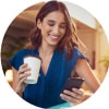 Image of woman looking at her watch with coffee cup in one hand