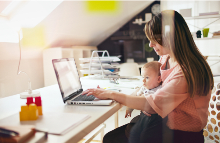 working mom with child on her lap looking at laptop