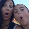 Woman and her daughter taking a silly selfie with their mouths open in surprise