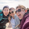Faces of three women in an outdoor adventure taking a selfie